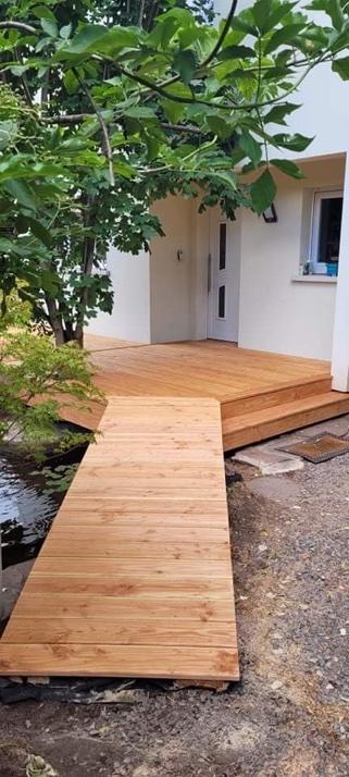 Terrasse et passerelle en bois menant à l'entrée d'une maison